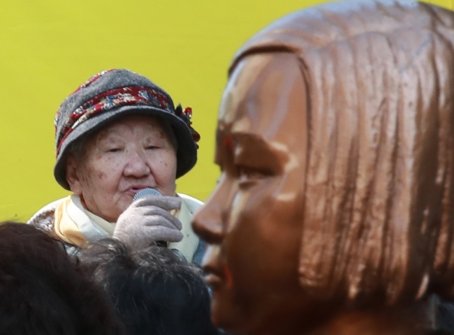 Gil Won-ock, one of the Korean victims of Japan's wartime sexual slavery during World War II, speaks during a public rally in front of the Japanese Embassy in Seoul on Oct. 17. The statue of a young girl (right), erected in front of the embassy, honors the vicitms. (Yonhap)