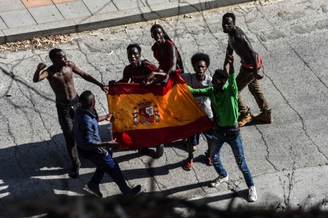 Migrants from Morocco celebrate crossing into Spain (AFP)