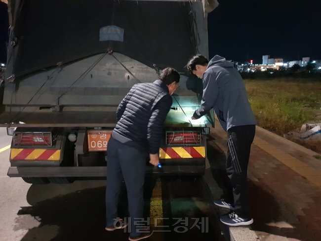 포항시 공무원들이 29일 밤 9시께 침출수가 흘러내리고 있는 포스코 수재슬래그 운반 차량에 대한 현장 단속에 나서고 있다. [사진=김병진 기자]