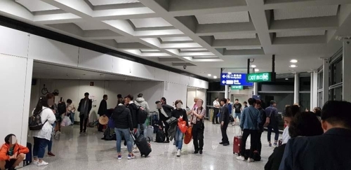 Passengers wait in the hallways at Hong Kong International Airport after a Vietjet flight made an emergency landing on Tuesday, Oct. 30. (Yonhap)