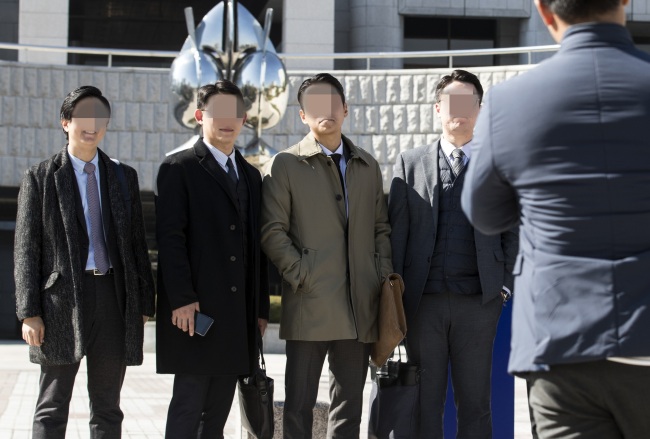 South Korean members of Jehovah's Witnesses pose for photos in front of the Supreme Court in Seoul on Thursday, after the top court ruled that religious beliefs are to be considered as valid reasons for refusing the country’s mandatory military service. (Yonhap)