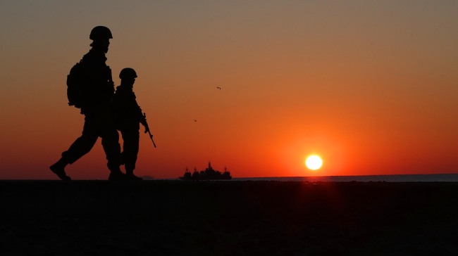 Two soldiers walk along the coastline of Yeonpyeong island for a patrol missino. Yonhap