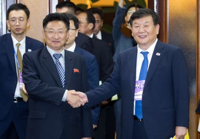 South Korean Vice Sports Minister Roh Tae-kang (right) shaking hands with North Korean Vice Sports Minister Won Kil-u (Yonhap)