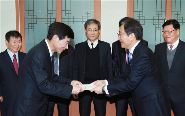 성윤모 산업통상자원부 장관(오른쪽)이 7일 서울 여의도 한전 집무실에서 제3차 에너지기본계획 워킹그룹의 권고안을 제출받고 있다. 이 권고안에는 2040년까지 재생에너지 발전 비중을 최소 25%까지 확대하되 총 에너지 소비를 현 수준으로 유지하는 내용을 담고 있다.  [연합뉴스]