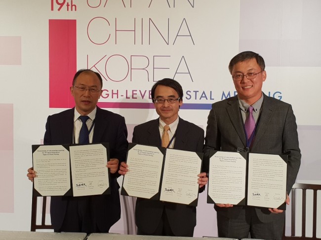 From right: Kang Seong-ju, Korea Post president, Kunio Tanigaki, vice president of Japan Post, and Kang Ning, vice president of China Post Group, pose after signing a memorandum of understanding on sharing innovative postal services and forming a task force team for swift customs clearance of mail across borders, in Tokyo on Thursday. (Korea Post)