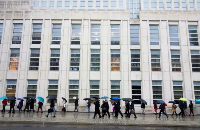 The prosecution team (center in black) walks past a line of people outside the Brooklyn federal courthouse before opening arguments in Guzman's trial on November 13, 2018 (AFP)