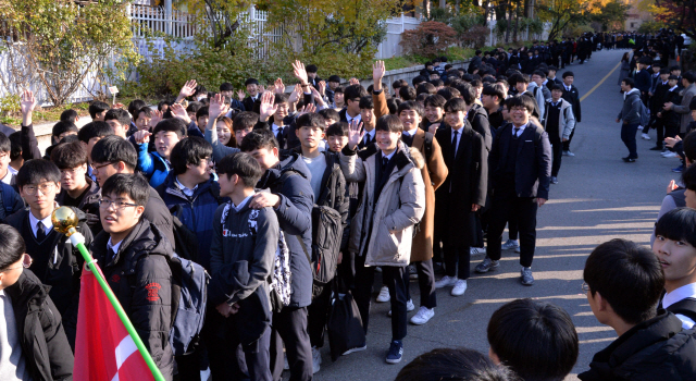 2018년 수능시험이 하루 앞으로 다가왔다. 14일 고3 수험생들은 각 학교별로 예비소집을 위해 일찍 수업을 마쳤다. 시험을 치르는 수험생을 위해 후배들은  출정식으로 사기를 북돋웠다. 서울 용산고등학교 재학생과 수험생들이 예비소집을 위해 학교문을 나서는 고3선배를 위해 사물놀이로 응원하고, 선생님들이 허그를 해주며 응원했다.  정희조 기자/checho@heraldcorp.com