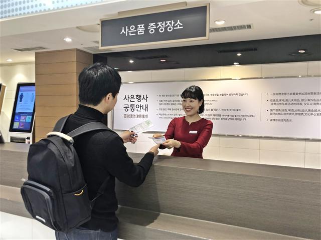 롯데백화점 사은품 증정 장소에서 5000원 상품권을 증정받는 수험생 모습.  [제공=롯데백화점]