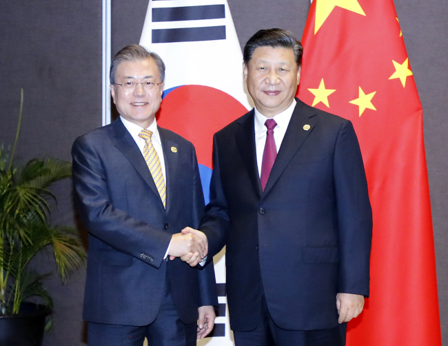 South Korean President Moon Jae-in shakes hands with Chinese President Xi Jinping on the sidelines of the Asia Pacific Economic Cooperation forum in Papua New Guinea on Saturday. (Yonhap)