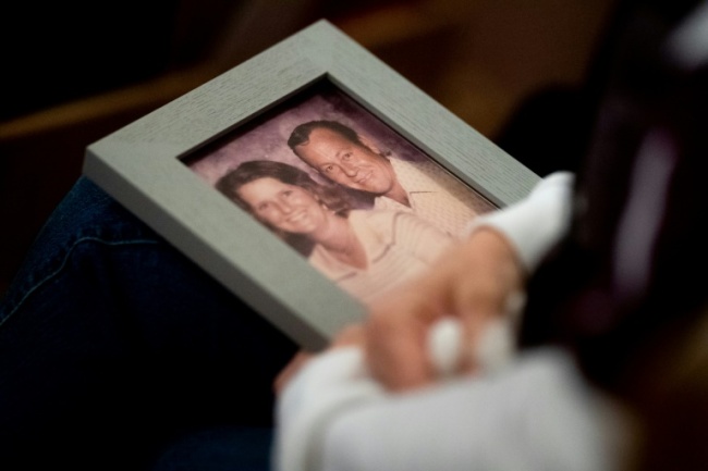 During a church vigil in Chico, California, for victims of the Camp Fire, Laura Martin holds a picture of TK Huff, her father who died in the blaze (AFP)