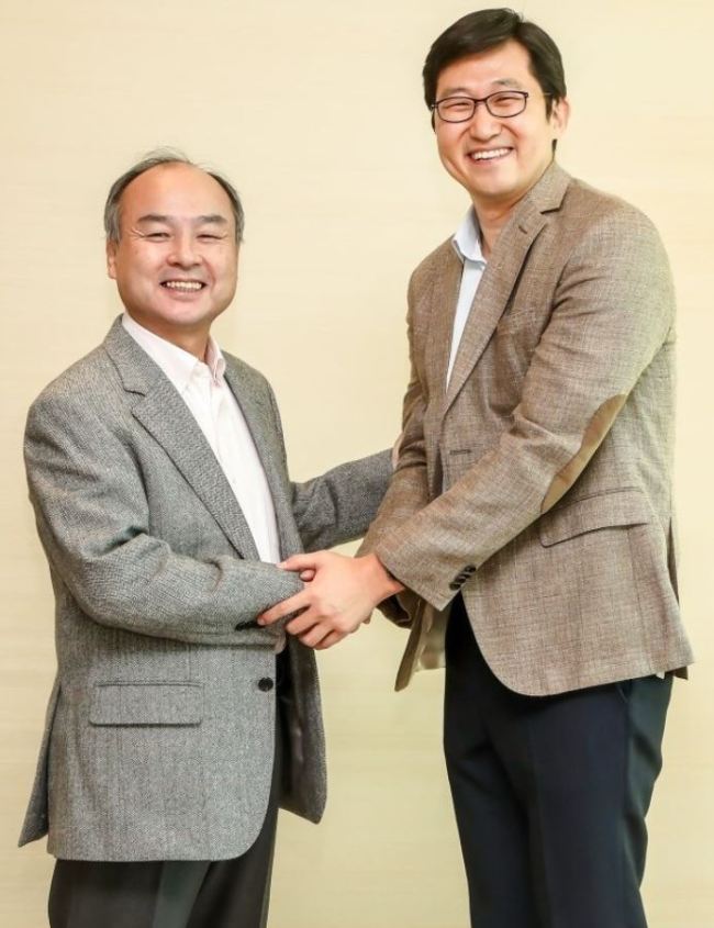 Coupang CEO Kim Bom (right) poses with SoftBank founder and CEO Masayoshi Son earlier this month at the SoftBank headquarters in Toyko. (Coupang)