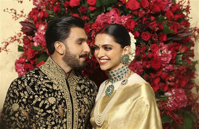 <YONHAP PHOTO-5225> Bollywood actors Deepika Padukone, right, and Ranveer Singh pose at their wedding reception in Bangalore, India, Wednesday, Nov. 21, 2018. The couple got married at Villa Balbianello, a lakeside mansion featured in Star Wars and James Bond films in Lenno, Como lake, northern Italy on Nov. 14, 2018. (AP Photo/Aijaz Rahi)/2018-11-21 23:34:48/ <저작권자 ⓒ 1980-2018 ㈜연합뉴스. 무단 전재 재배포 금지.>