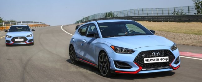 In this photo provided by Hyundai Motor Co., a pair of Hyundai Motor's Veloster N coupes sporting "performance blue" paint are driven on a racetrack in South Korea. (Yonhap)