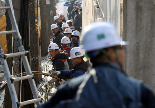 Officials from KT Corp. are making efforts to normalize the network at the company's building in the central Ahyeon district of Seoul on Sunday which caught fire a day earlier. (Yonhap)