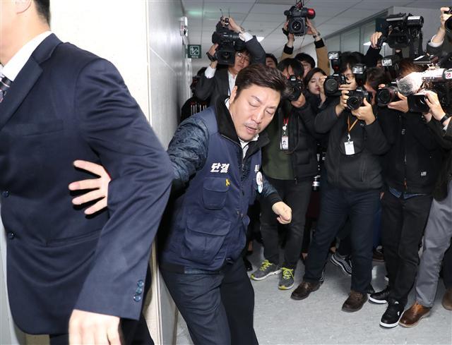 장경호 전국금융산업노동조합 우리카드 지부장(가운데)이 26일 오전 국회 의원회관에서 열린 카드수수료 개편방안 당정협의 회의장에 진입을 시도, 국회 관계자에게 저지당하고 있다. [연합뉴스]