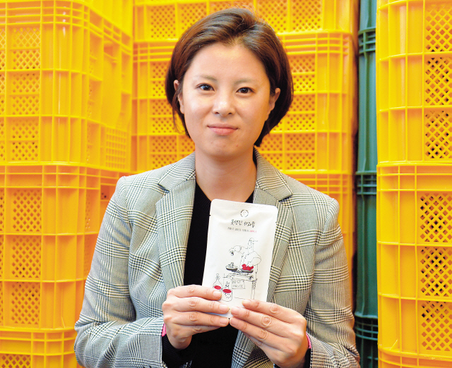 민금채 지구인컴퍼니 대표. 사무실 한 편에는 못난이 농산물로 만든 과일즙이 담은 플라스틱 상자가 가득했다.  [사진=윤병찬 기자/yoon4698@]