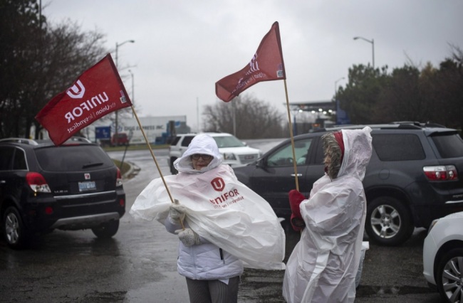 Members of Unifor, the union representing the workers of Oshawa's General Motors assembly plant, stand near the entrance to the plant in Oshawa, Ontario, Monday, Nov. 26, 2018. General Motors will lay off thousands of factory and white-collar workers in North America and put five plants up for possible closure as it restructures to cut costs and focus more on autonomous and electric vehicles. General Motors is closing the Oshawa plant. (AP)