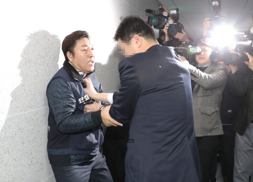 장경호 전국금융산업노동조합 우리카드 지부장(왼쪽)이 26일 오전 국회 의원회관에서 열린 카드수수료 개편방안 당정협의 회의장에 진입을 시도, 국회 관계자에게 저지당하고 있다. (사진=연합뉴스)