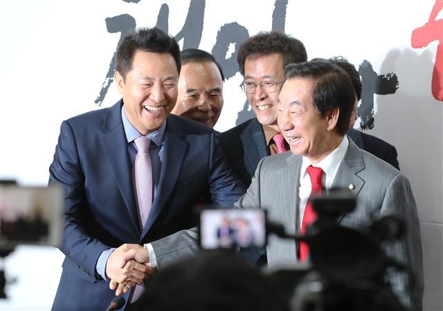 오세훈 전 서울시장(왼쪽)이 29일 오전 국회에서 열린 자유한국당 입당 환영식에서 김성태 원내대표와 반갑게 인사하고 있다.  [연합뉴스]