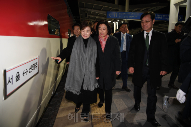 김현미 국토교통부 장관 을 비롯한 남북철도공동조사단 남측대표단이 30일 오전 서울역을 출발하기 앞서 서울역에서 신의주로 가는 표지판이 붙은 열차를 살펴 보고 있다. [사진공동취재단]