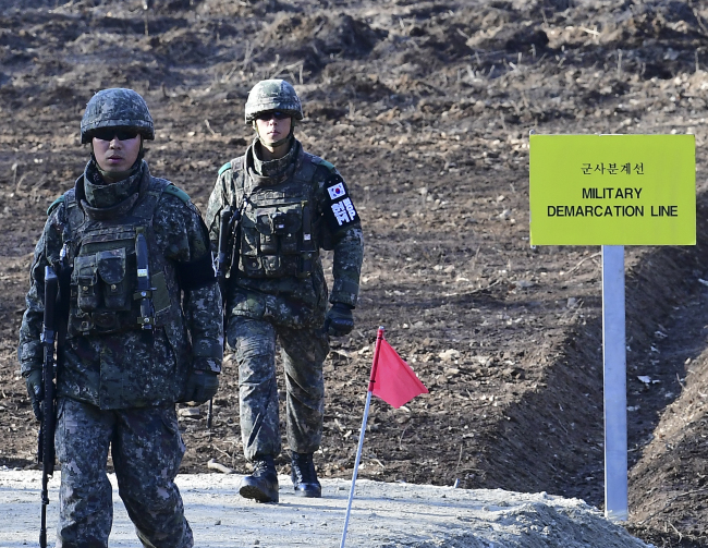 South Korean soldiers walk while building a tactical road across the Military Demarcation Line inside the Demilitarized Zone in Gangwon Province in this Nov.22 file photo. (AP-Yonhap)