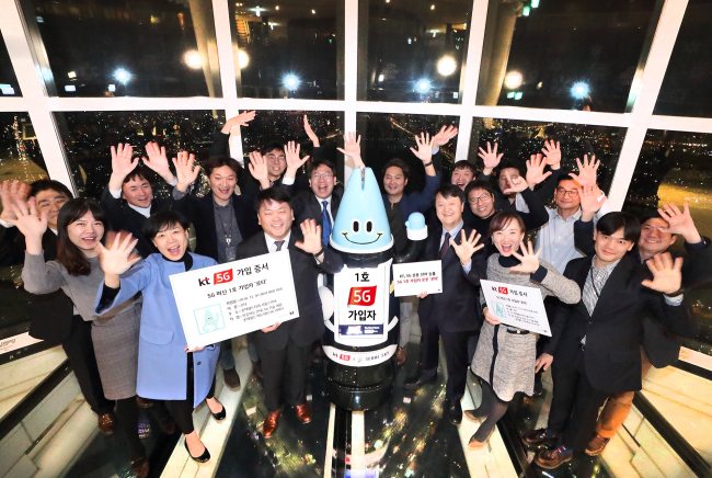 Artificial intelligence guide robot Lota(center), KT Corp.'s first subscriber for 5G services.