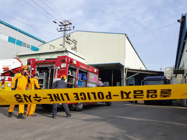 This photo, taken on Wednesday, shows fire fighters dealing with a toxic gas leak at a waste water treatment plant in the southern port city of Busan. (Yonhap)