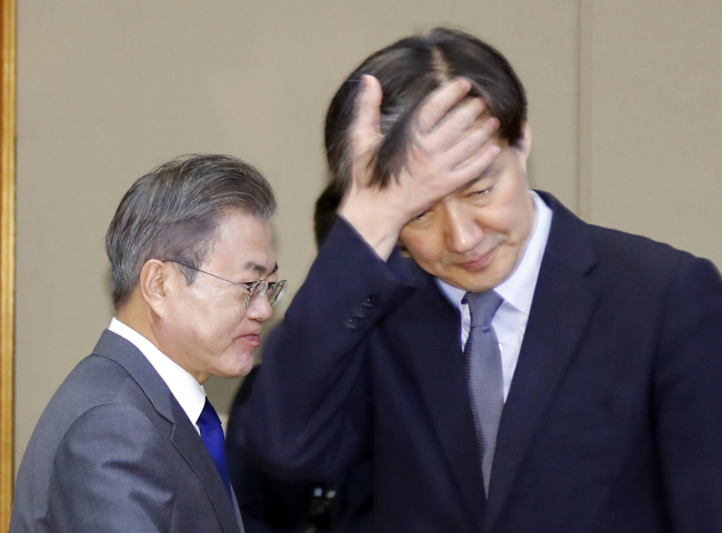 President Moon Jae-in and his Senior Secretary for Civil Affairs Cho Kuk at a senior aides meeting held on Nov. 20. Yonhap