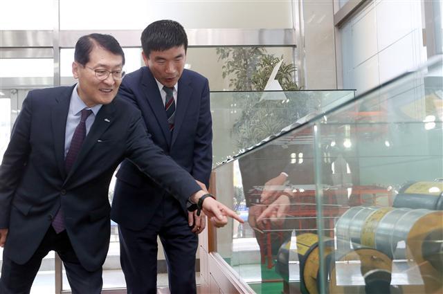 신한은행 위성호 은행장(왼쪽)이 지난달 13일 인천광역시 소재 자동차 부품업체 대주중공업을 방문해 박주정 대표이사로부터 제품에 대해 설명을 듣는 모습.  [제공=신한은행]