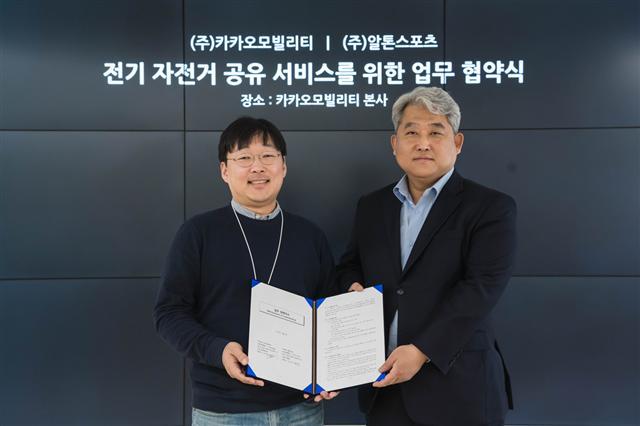 카카오모빌리티 정주환 대표(왼쪽)과 알톤스포츠 김신성 대표가 ‘전기 자전거 공유 서비스를 위한 업무 협약’을 맺고 기념사진을 찍고 있다.  [제공=카카오모빌리티]