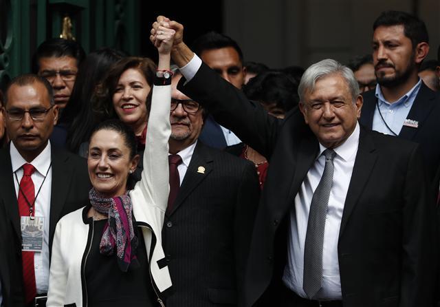 <YONHAP PHOTO-0979> The first elected female mayor of Mexico City Claudia Sheinbaum and President Andres Manuel Lopez Obrador lift their arms in unison after she was sworn into office, in Mexico City, Wednesday, Dec. 5, 2018. (AP Photo/Moises Castillo)/2018-12-06 03:49:46/ <저작권자 ⓒ 1980-2018 ㈜연합뉴스. 무단 전재 재배포 금지.>