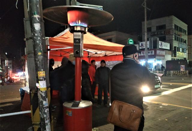 ‘오늘은 일이 있으려나….’ 한파가 강타한 7일 새벽 서울 남구로 인력시장 천막 옆 히터 앞에 일감을 찾는 인부들이 몸을 녹이고 있다. 김성우 기자/zzz@