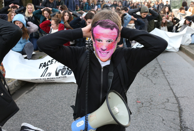 <YONHAP PHOTO-4175> A student wearing a mask of French President Emmnanuel Macron puts his hands on his head as school children demonstrate in Bayonne, southwestern France, Tuesday Dec.11, 2018. Macron has acknowledged he's partially responsible for the anger that has fueled weeks of protests in France, an unusual admission for the leader elected last year. (AP Photo/Bob Edme)/2018-12-11 20:23:30/ <저작권자 ⓒ 1980-2018 ㈜연합뉴스. 무단 전재 재배포 금지.>
<YONHAP PHOTO-4175> A student wearing a mask of French President Emmnanuel Macron puts his hands on his head as school children demonstrate in Bayonne, southwestern France, Tuesday Dec.11, 2018. Macron has acknowledged he's partially responsible for the anger that has fueled weeks of protests in France, an unusual admission for the leader elected last year. (AP Photo/Bob Edme)/2018-12-11 20:23:30/ <저작권자 ⓒ 1980-2018 ㈜연합뉴스. 무단 전재 재배포 금지.>