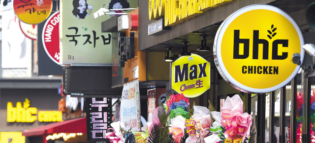 올해에 이어 내년도 최저임금 인상을 앞두고 인건비 부담으로 24시간 영업을 중단하는 프랜차이즈 가맹점주들이 늘고 있다. 사진은 프랜차이즈 간판이 늘어선 서울시내 거리 모습.   [연합뉴스]