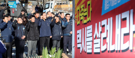 지난 10일 '카카오 카풀'에 반대하며 분신해 사망한 택시기사 최모 씨의 분향소가 12일 국회 앞에 설치돼 택시단체 회원들이 구호를 외치고 있다. (사진=연합뉴스)