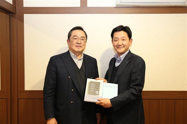 구자열 LS그룹 회장이 14일 LS용산타워에서 신규 임원이 된 LS산전 박석원 이사에게 책을 선물하고 있다 .[제공=LS그룹]