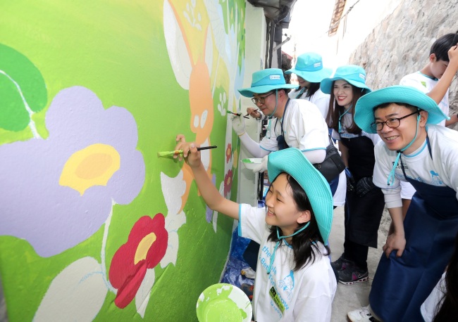 Daewoo E&C workers and their families paint murals in Seoul as part of the firm’s CSR activities. (Daewoo E&C)