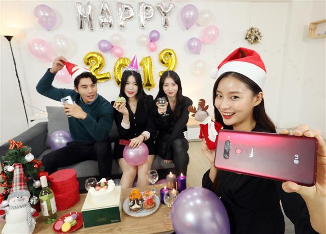 LG전자 모델들이 ’LG V40 ThinQ‘로 크리스마스 기념 사진을 촬영하고 있다.  [제공=LG전자]