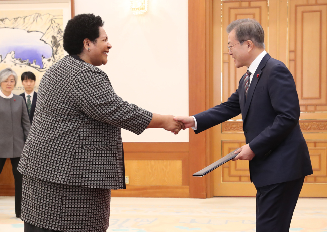 President Moon Jae-in (right) greets Ambassador Peniana Lalabalavu from Fiji, Dec. 27 (Yonhap)