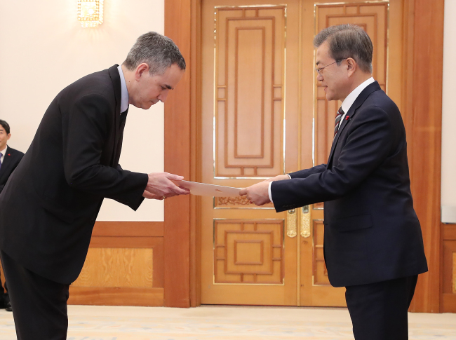 President Moon Jae-in (right) greets Ambassador Michael Danagher from Canada, Dec. 27 (Yonhap)