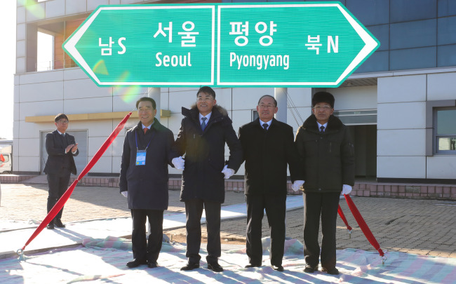 Officials unveil a signboard pointing to South Korea's capital city of Seoul and North Korea's Pyongyang at Panmun Station, Kaesong on Wednesday. (Joint Press Corps)