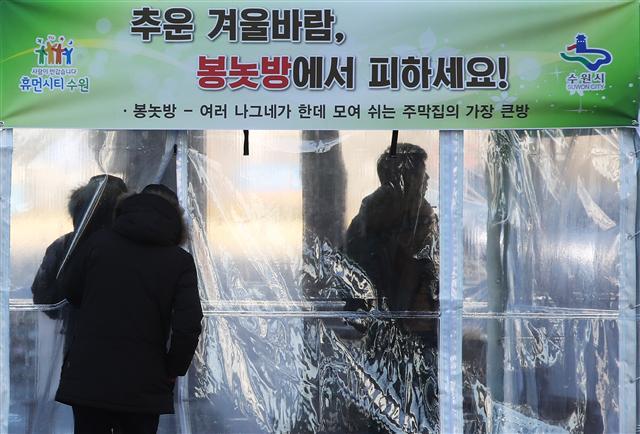 강력한 한파가 몰아친 27일 오전 경기도 수원시 팔달구 수원시청 앞 버스정류소에 설치된 온기 텐트에서 시민들이 추위를 피하고 있다. [연합뉴스 ]