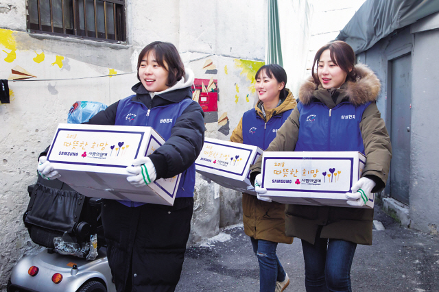 지난 5일 삼성전자 임직원들이 서울 동대문구에 위치한 쪽방을 찾아 거주하는 어르신들에게 전달할 생필품 세트를 나르고 있다.  [제공=삼성전자]