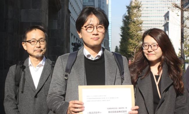 This photo, taken on Dec. 4, 2018, shows a Japanese activist and two South Korean lawyers representing the four victims of Japan's wartime forced labor showing a document calling on Nippon Steel & Sumitomo Metal Corp. to carry out the top court's order to compensate the victims before visiting the headquarters of the Japanese firm in Tokyo. (Yonhap)