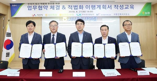 충남 서산축협관계자들이 지난해 8월21일 관계 기관들과 무허가 축사 합법화 이행을 위한 업무협약을 체결한 뒤 기념촬영을 하고 있다.  [제공=농림축산식품부]