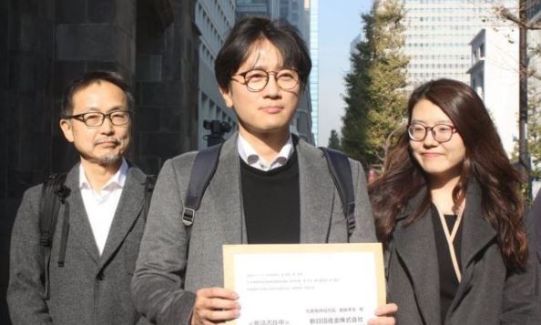 A Japanese activist (first left) and two South Korean lawyers representing the four victims of Japan`s wartime forced labor showing a document calling on Nippon Steel & Sumitomo Metal Corp. to carry out the top court`s order to compensate the victims on Dec. 4 2018. (Yonhap)