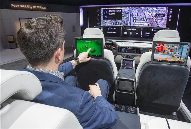 삼성전자가 CES 2019에서 최초 공개한 ‘삼성봇 케어’. 삼성봇 케어가 사람의 맥박과 혈압을 측정하고 있는 모습(사진 왼쪽). 삼성전자 부스에서 삼성전자 모델이 개인에게 최적화된 환경과 인포테인먼트 시스템을 제공하는 차량용 ‘디지털 콕핏 2019’를 시연하고 있다. [제공=삼성전자]