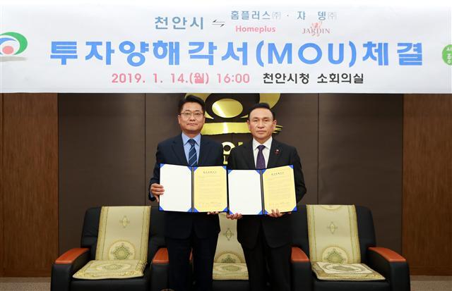 전화수 홈플러스 운영지원부문장(왼쪽)과 구본영 천안시장이 지난 14일 충청남도 천안시 불당동 천안시청에서 대규모 ‘미트센터(Meat Center)’ 건립을 위한 투자협약(MOU)을 체결한 후 협약서를 들어보이고 있다.  [제공=홈플러스]