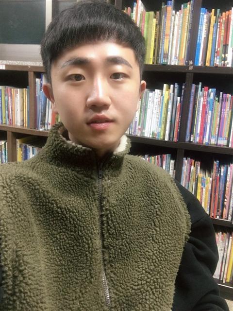 지난 13일 오후 서울 지하철 암사역 3번 출구 앞 인도에서 박모 군이 쓰러진 채 한모 군에게 폭행 당하는 가운데 이명은(사진 뒷모습)씨가 이를 말리려 달려가고 있다.  [사진=목격자 동영상 캡처]