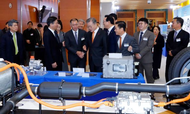 President Moon Jae-in (center) looks at a model of the hydrogen fuel cell electric vehicle Nexo during a visit to a Hyundai Motor facility in Ulsan on Thursday. (Yonhap)